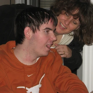 Mom wheeling Alex into his Texas room