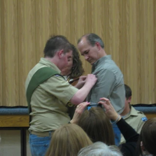 Alex at his eagle court of honor pinning a badge on Dad