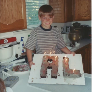 Alex holding an 'AL' birthday cake