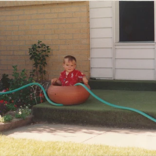 Alex playing in a big pot as a toddler