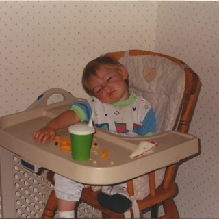 Alex asleep at a high chair