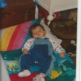 Alex sleeping on the ground as a baby