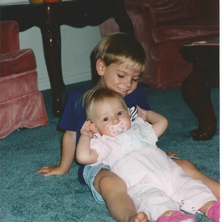 Alex sitting on the ground holding Nicole