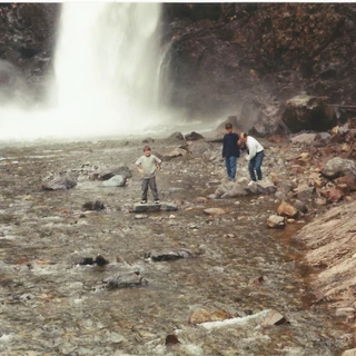 Alex standing on a rock by a waterfall