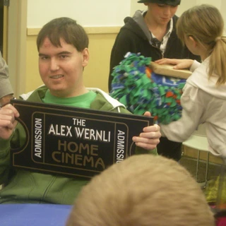 Alex holding his home cinema sign