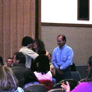 Alex at a scout ceremony hugging mom