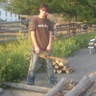 Alex holding a chain saw at his eagle project