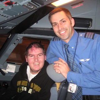 Alex in the cockpit of the plane with the pilot