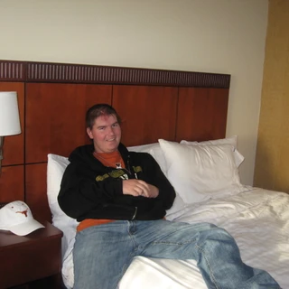 Texas sitting on his hotel bed