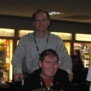 Dad pushing Alex in a wheelchair at the airport