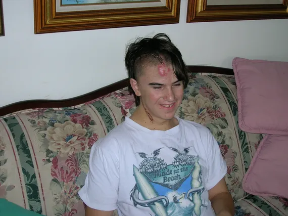 Alex smiling sitting on the couch at home