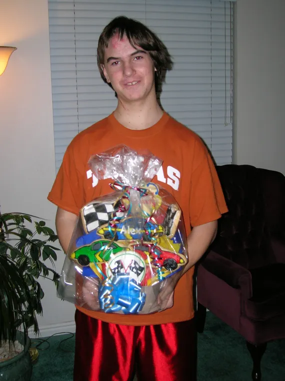 Alex in his Texas shirt holding a gift basket