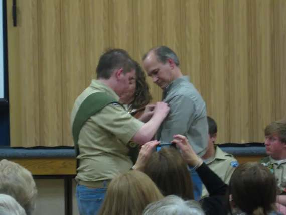 Alex at his eagle court of honor pinning a badge on Dad