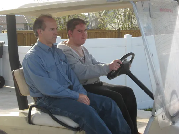 Alex and Dad driving the golf cart