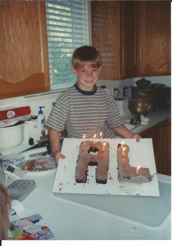 Alex holding an 'AL' birthday cake
