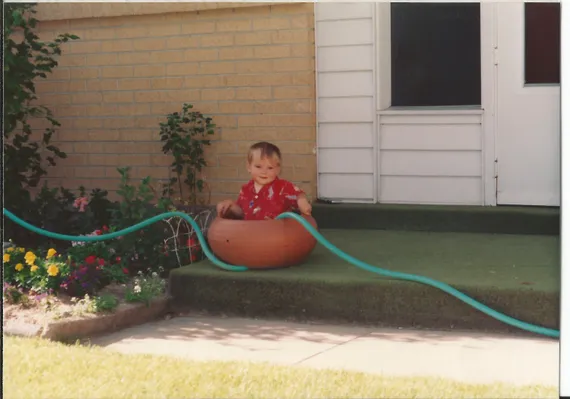 Alex playing in a big pot as a toddler
