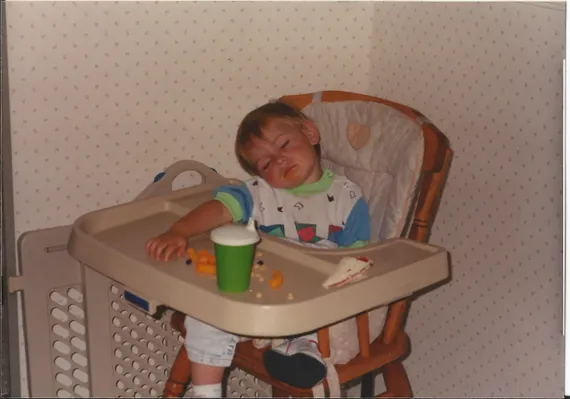 Alex asleep at a high chair