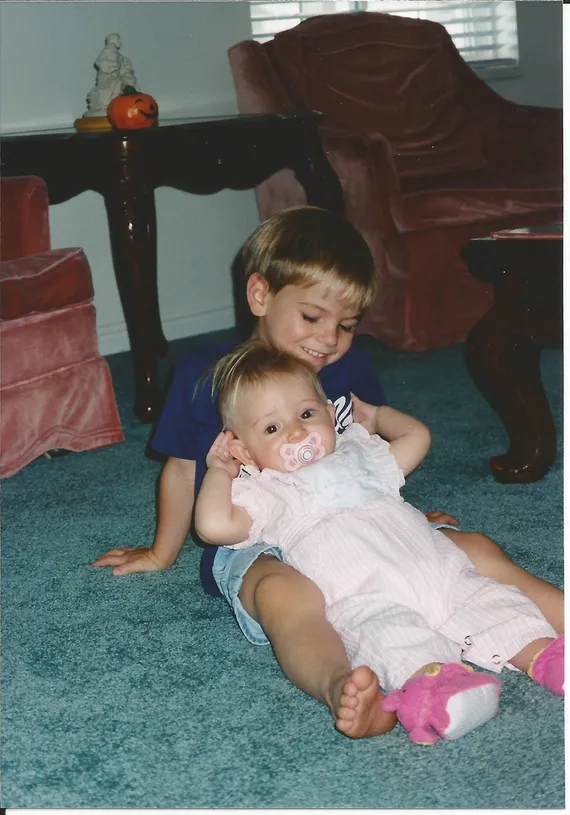 Alex sitting on the ground holding Nicole