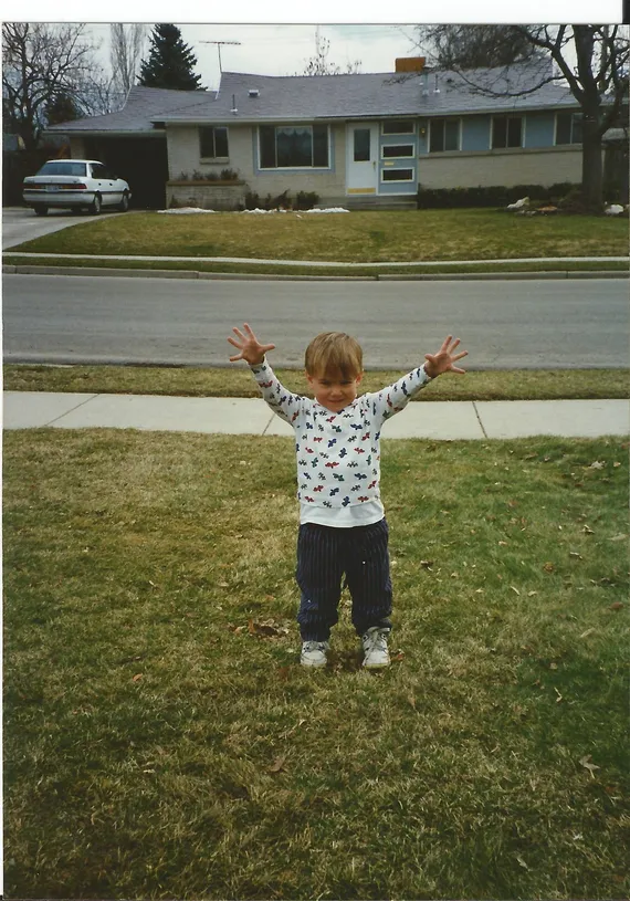 Alex holding his arms up as a toddler