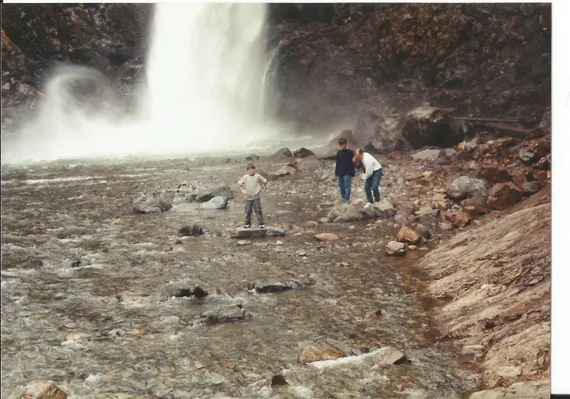 Alex standing on a rock by a waterfall