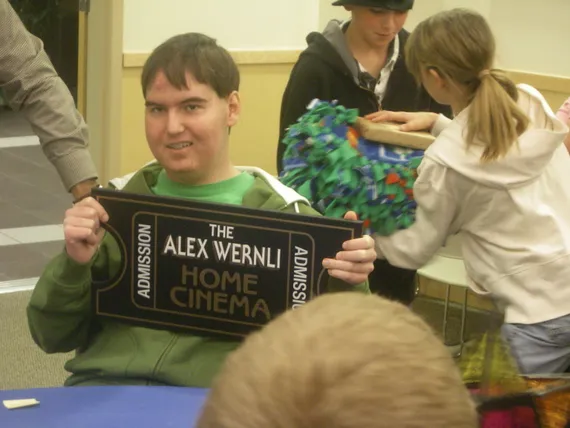 Alex holding his home cinema sign