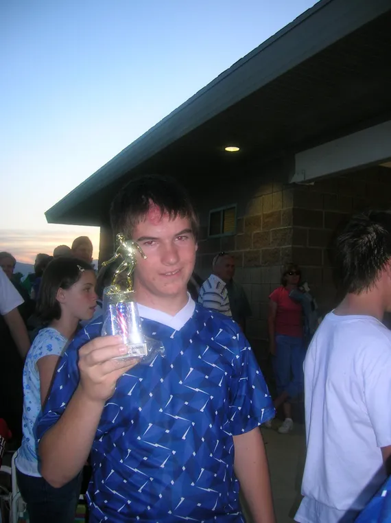 Alex holding a soccer trophy