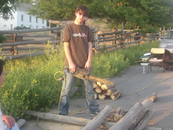 Alex holding a chain saw at his eagle project