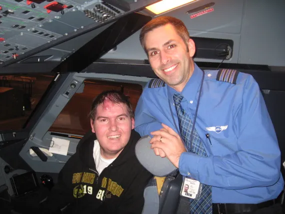 Alex in the cockpit of the plane with the pilot