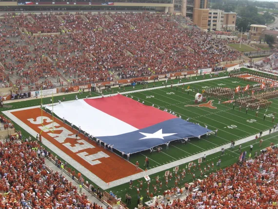Texas Football field with the flag and band