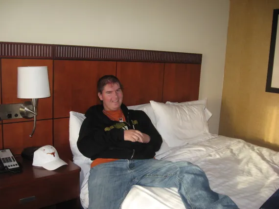 Texas sitting on his hotel bed