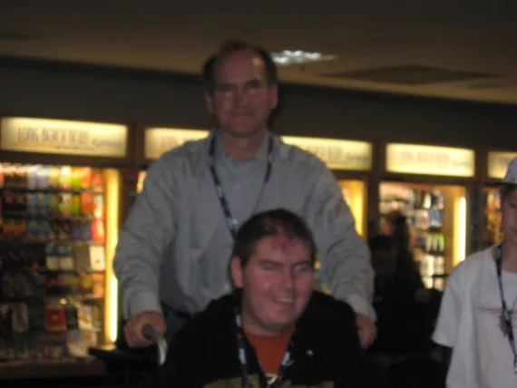 Dad pushing Alex in a wheelchair at the airport